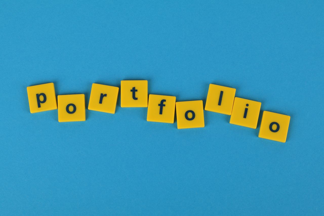 Yellow Scrabble tiles set against a blue backdrop spelling portfolio. Ideal for business-themed designs.